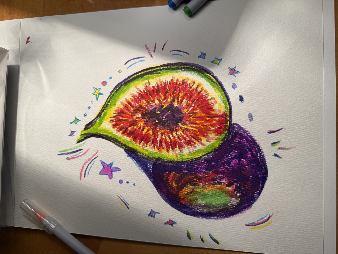 Marker drawing of a sliced fig surrounded by colorful stars and sparkles