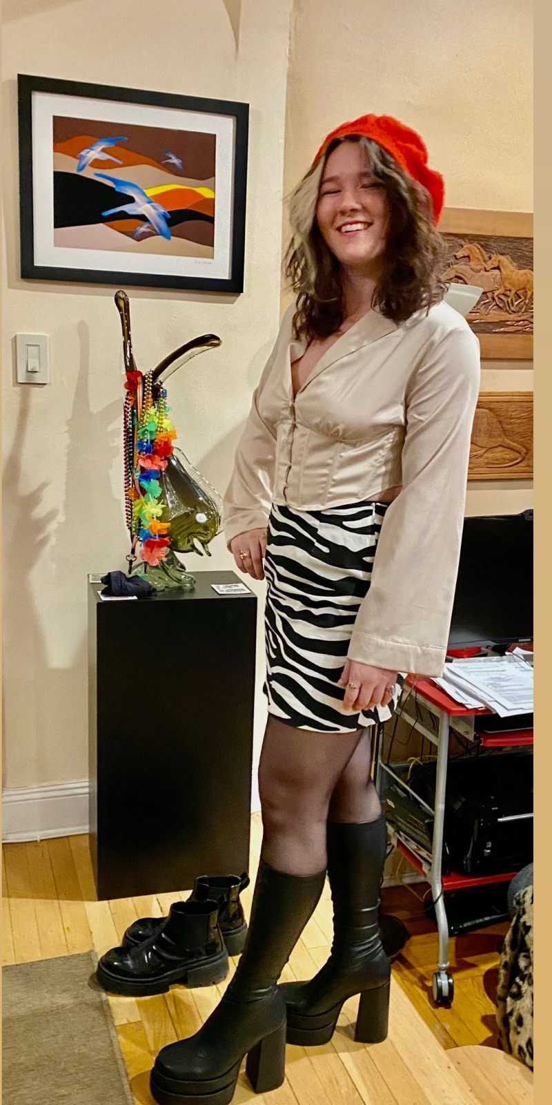 The maker in a red beret, zebra print skirt, and tall black platform boots